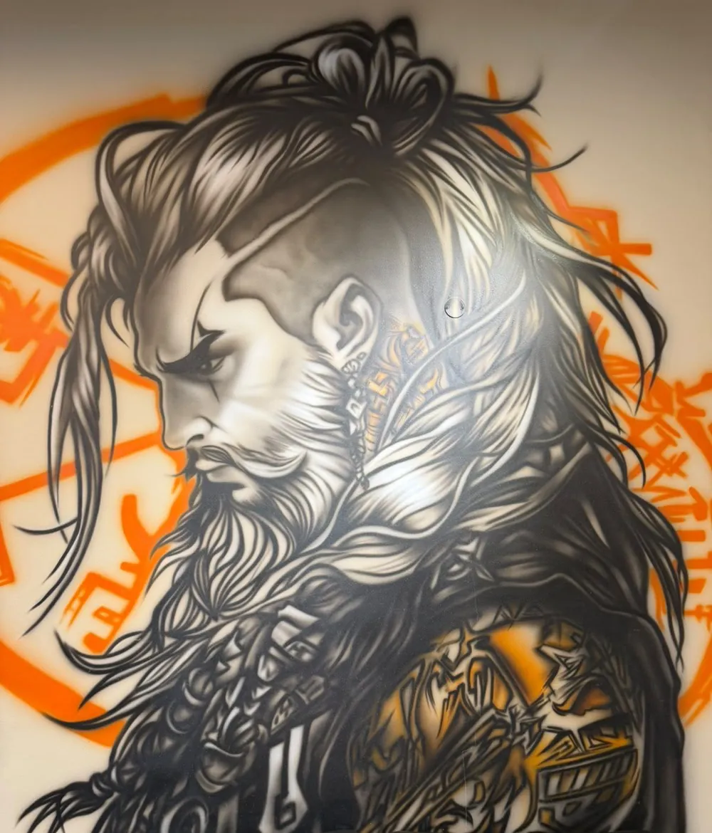 Airbrushed mural on the salon wall: a bearded warrior with long braided hair, set against orange brush strokes